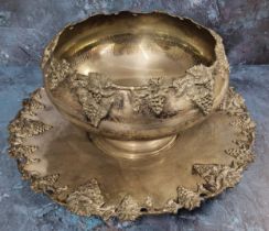 A silver metal punch bowl and stand, applied with bold fruiting vine border, the stand 41cm diam,