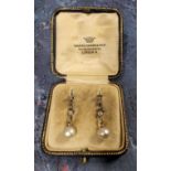 A pair of Art Deco diamond & pearl drop earrings, a brilliant cut diamond, rub set in a plain