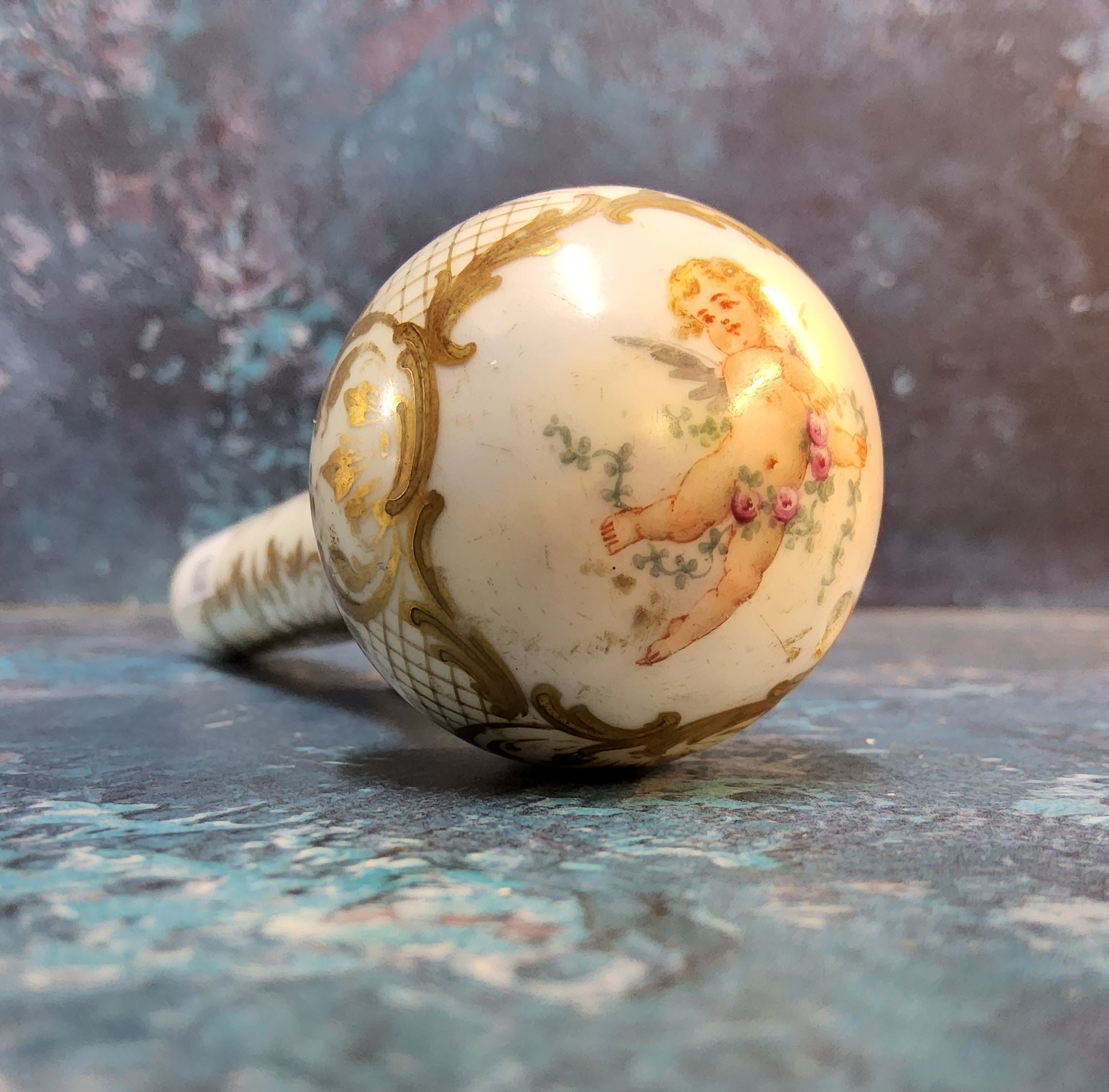 A Victorian porcelain parasol handle, decorated with cherubs within a gilt cartouche, on a white - Image 3 of 4