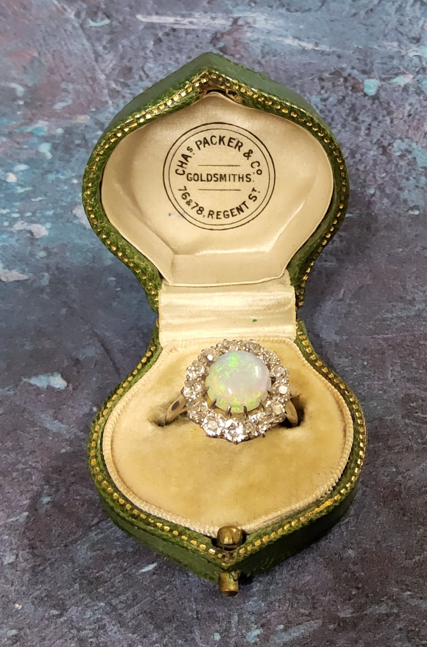 An 18ct white gold, crystal opal & diamond floral ring, the central circular cabochon crystal opal