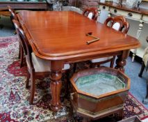 A clean Victorian style dining table, boldly turned and reeded legs terminating on castors; four