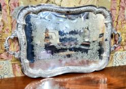 A Victorian plate shaped rectangular two handled tray, the field engraved and chased with foliage