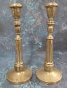 A pair of silver coloured metal table candlesticks, fluted nozzles, spreading cylindrical fluted