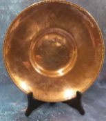 Harold Holmes - a copper circular dish, engraved with stylised poppy, hammered, folded rim, 28cm