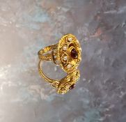 A 9ct gold etruscan style cocktail ring, set with a central oval garnet cabochon, the gold border