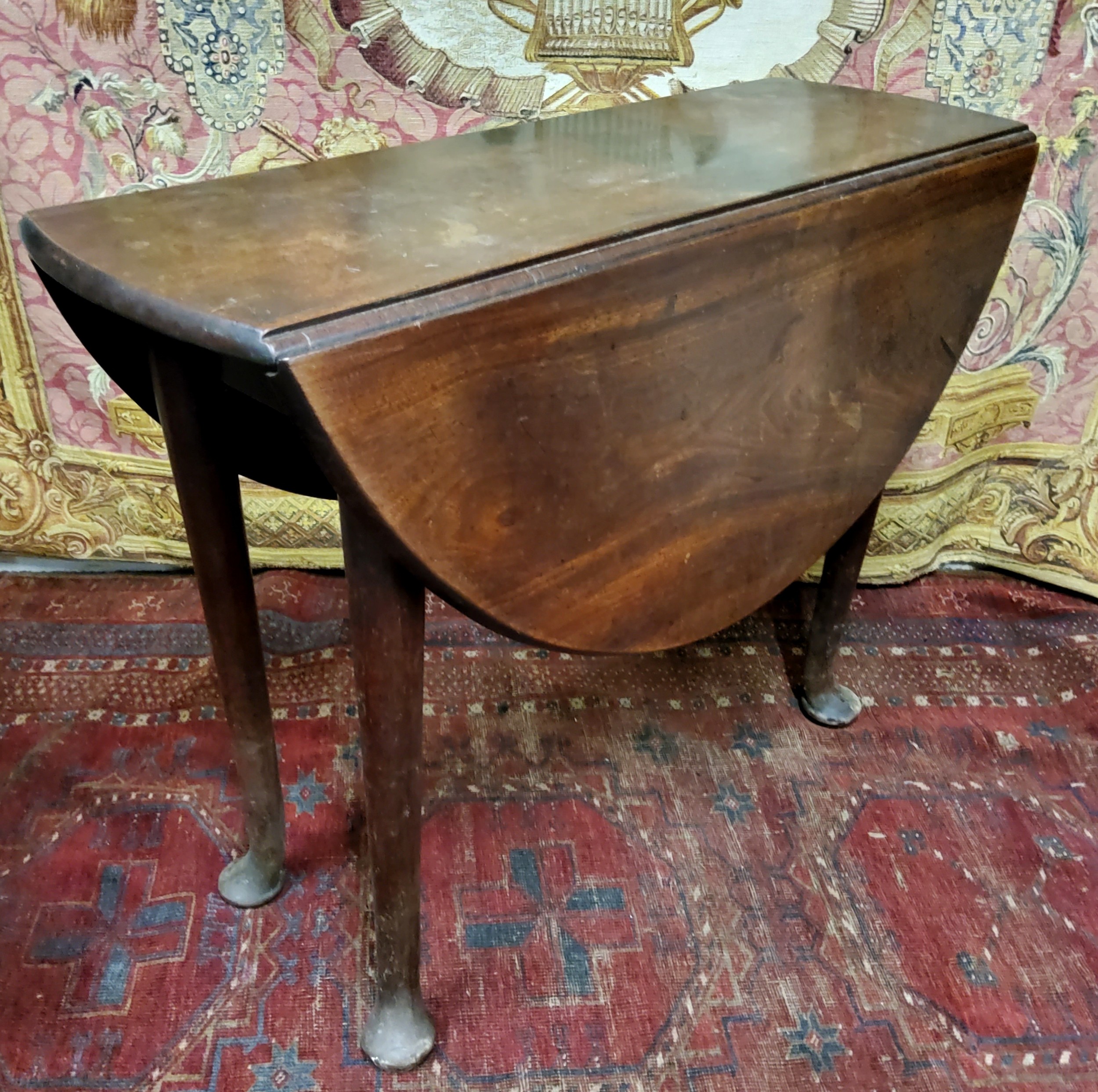 A George II mahogany gateleg table, oval top with fall leaves, tapered legs, pad feet, 71.5cm