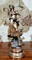 A 19th century French bronze of a lady during the harvest, raised on a later base, 55cm high