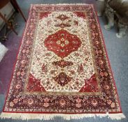 A large early 20th century Isfahan carpet, vivid tones of maroon, blue, ivory and gold, hand woven.