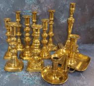 A pair of brass ejector candlesticks, reel shaped scones, knopped columns, canted square base,