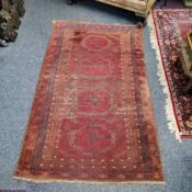 A 19th century Afghan rug in tones of maroon,  navy and gold