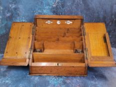 A late Victorian oak slope front desk top writing cabinet, hinged cover with perpetual calendar,