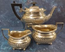 A Victorian silver three piece half fluted boat shaped bachelors tea service, comprising teapot,