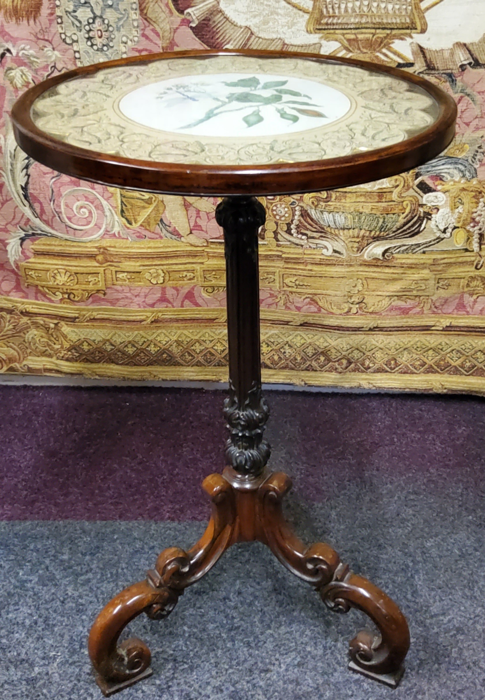An unusual rosewood wine table, the dished glazed top inset with circular hand painted watercolour