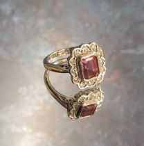 An 18ct white gold, pink Tourmaline & diamond cluster ring, the central Emerald cut pink Tourmaline,