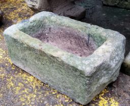 A Derbyshire gritstone trough, deeply carved-out, with drainage hole to base.