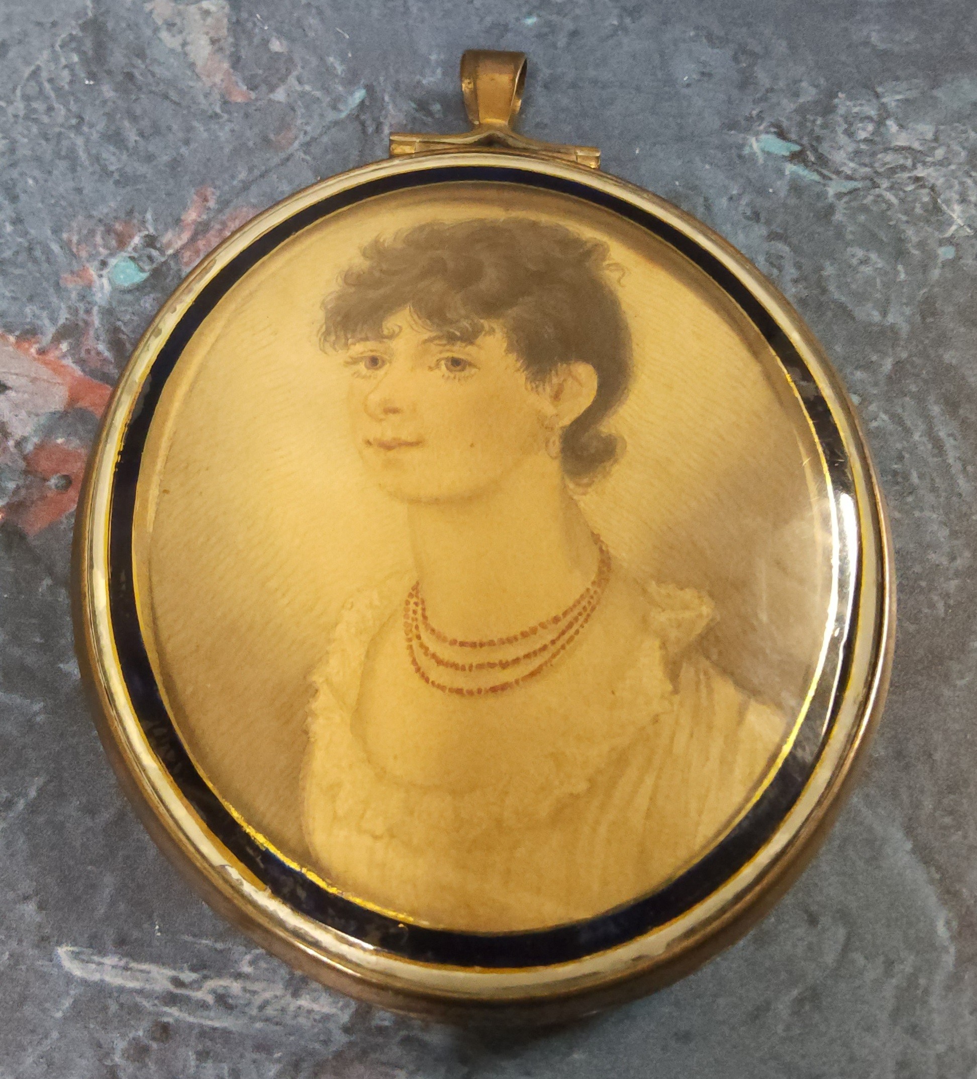 A George III miniature, of a young lady, wearing a beaded necklace, 6cm high, gilt metal frame