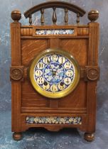 An Arts and Crafts oak mantel clock, the dial painted in blue with flowers and foliage, Arabic