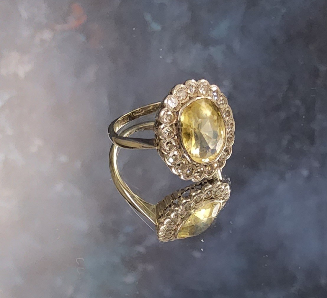 An 18ct white gold yellow sapphire & diamond cluster ring, the central oval yellow sapphire meas.