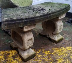 A reconstituted gritstone bowed garden seat.