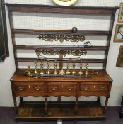 An 18th century oak dresser, moulded cornice, three open shelves, the base with three short drawers,