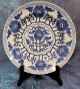 A Chinese shaped circular plate, painted in underglaze blue with stylised peonies, 25.5cm diam,