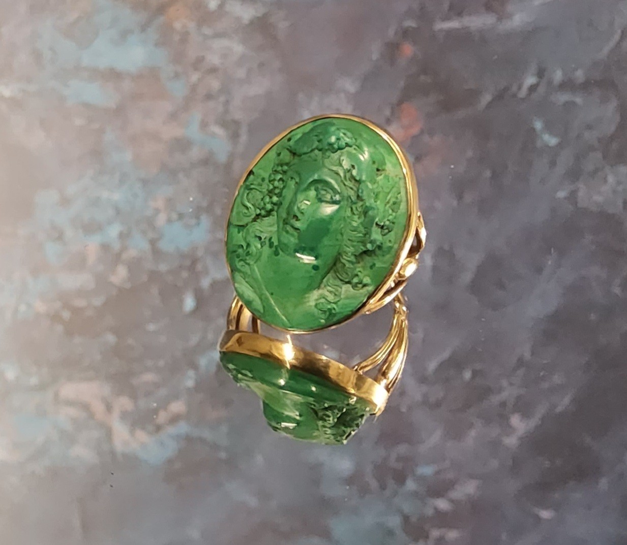 A 9ct gold green lava cameo ring, the oval lava cameo depicting a Greek maiden, 26 x 20mm, size M