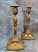 A pair of Sheffield Plated Egyptian Revival table candlesticks, urn shaped sconces, embossed with