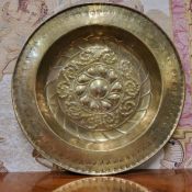 An early Dutch brass circular alms dish, repousse embossed with stylised floral roundel and scrolls,