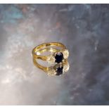 An 18ct gold sapphire & diamond trilogy ring, the claw set emerald cut sapphire 6 x 5mm flanked by