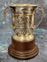 An Edwardian silver three handled trophy tyg, embossed with Art Nouveau stylised buds and scrolls,