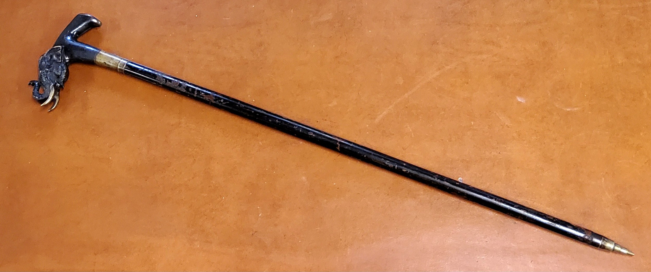 An Anglo Indian defence stick, the bronze handle cast with an elephant with trunk raised, ebonised