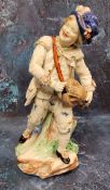 A Bristol Hurdy Gurdy figure, moulded by John Toulouse,  standing leaning on a stump, picked out