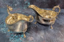 A pair of Edwardian silver sauce boats, beaded rim, c-scroll handle with leaf detail, raised on