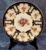 A Royal Doulton circular plate, painted by E Percy, signed, with basket of summer flowers within six