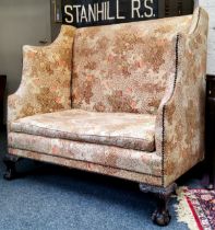 An early 20th century oak Country House high back hall sofa, leafy capped ball and claw feet,