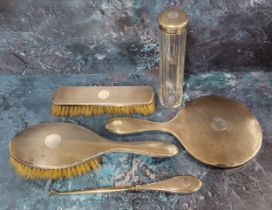 A George V silver backed dressing table set, comprising hair brush, hand mirror, clothes brush and