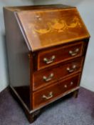 An early 20th century mahogany bureau, the fall front with urns and scrolls, above three drawers,