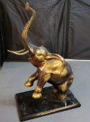 20th century, gilt bronze, elephant, with front legs and trunk raised, 'marbled' base, 46cm high