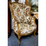 A French Louis XV Revival fauteuil à oreille, the shaped cresting carved with foliage, the wingback,