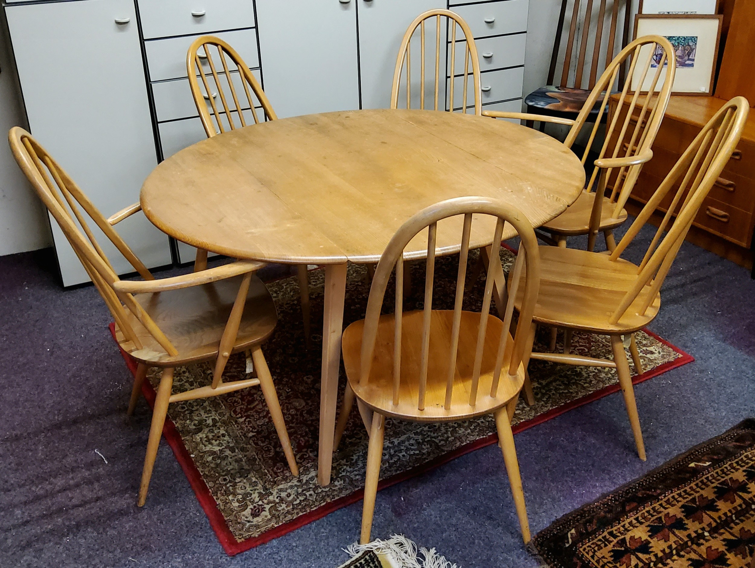 A blonde Ercol oval dining table, two carvers and four chairs (7)