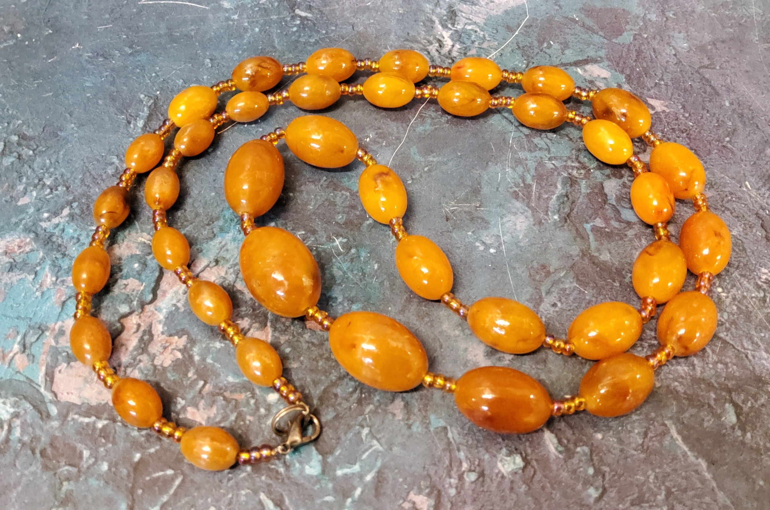 An amber coloured bead necklace, 100cm lone