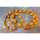 An amber coloured bead necklace, 100cm lone