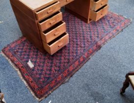 A 19th century hand knotted Eastern rug, red ground, 83in x 44in