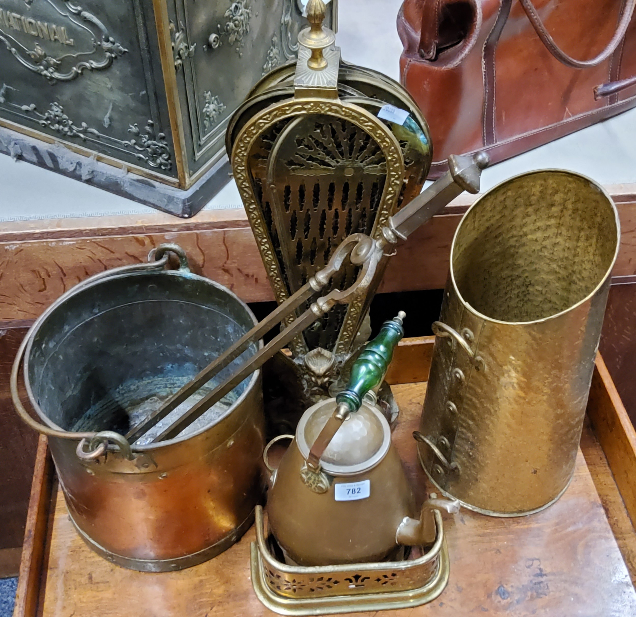 A brass 'peacock' fan shaped fire guard, 62cm high;  a set of brass fireside tongs;  fireside coal