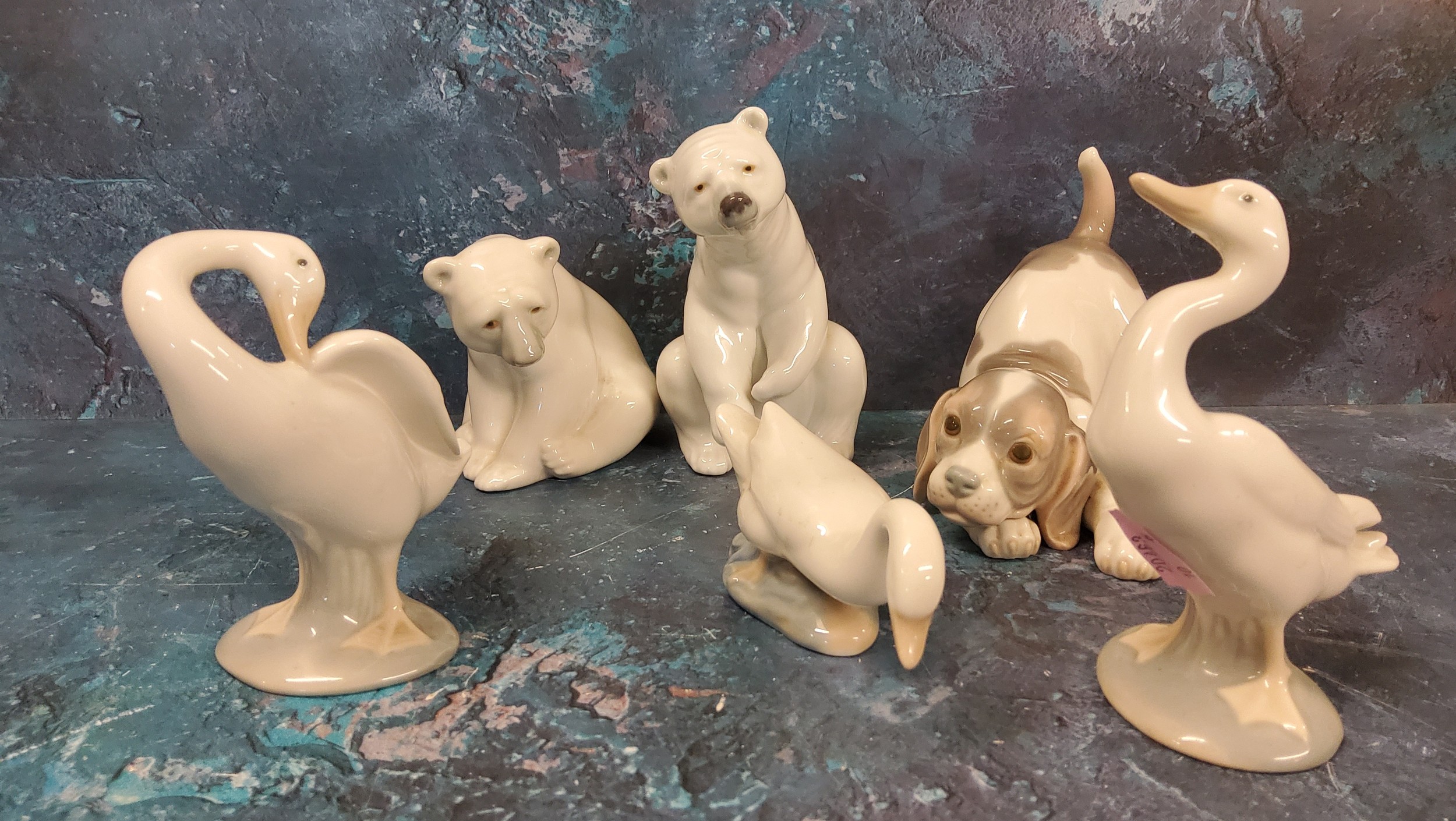 A Lladro model, of a polar bear, 11.5cm high, printed mark;  another;  playful puppy;  three