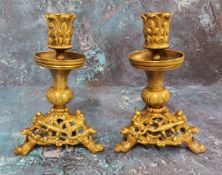 A pair of French gilt bronze candlesticks, the sconces cast with leaves, triform bases pieced and