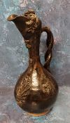 A Turkish Cannakale pottery ewer, , applied with stylised folaige, dark brown glaze, twisted handle,