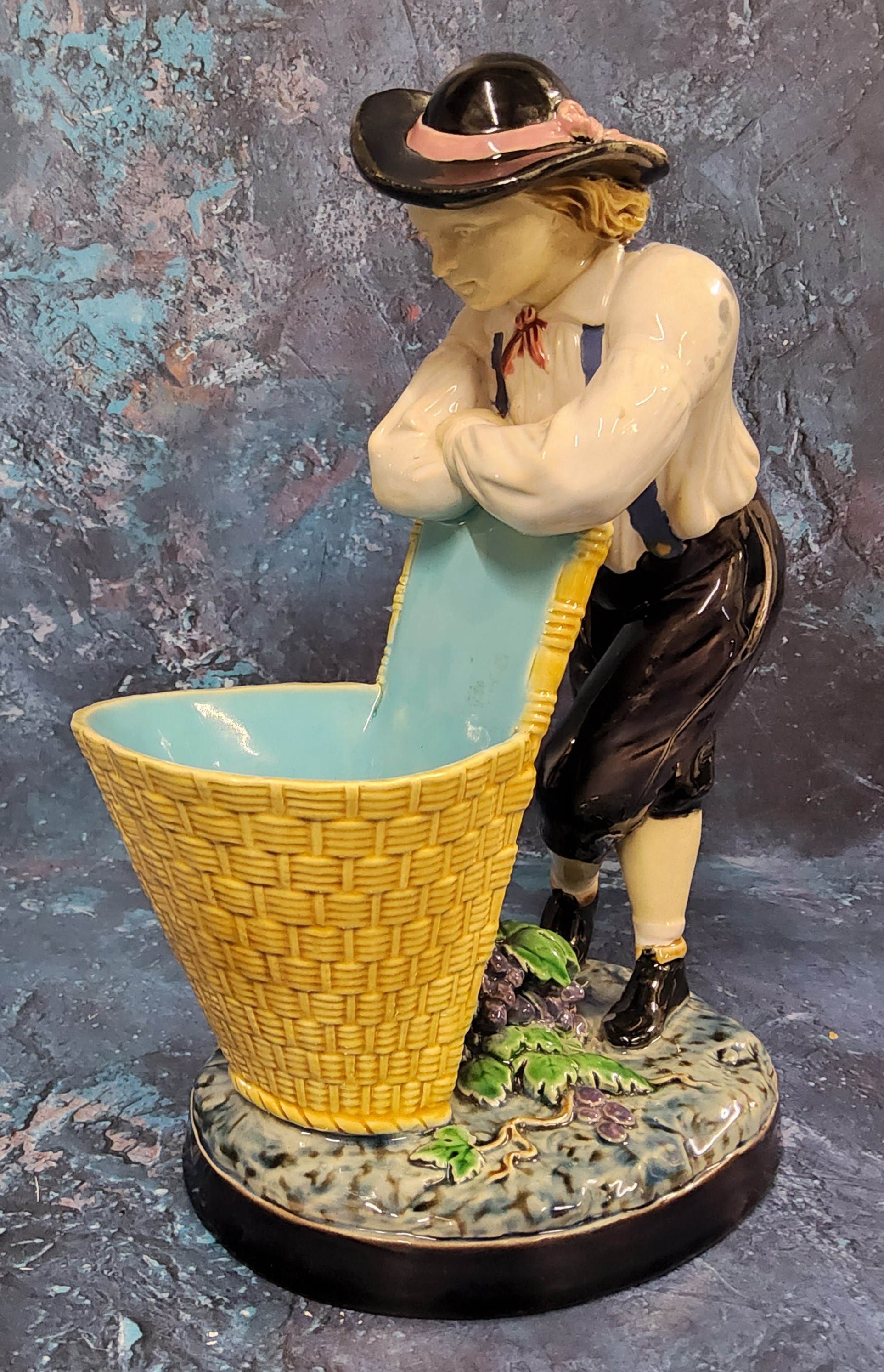 A Minton majolica figure, The Grape Picker, he stands leaning on his pannier, 24cm high, impressed - Image 3 of 7