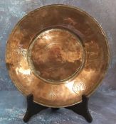 An Indian copper circular dish, engraved with alternate leaves and symbols, 28cm wide