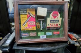 A framed display of reproduction razor brand labels; a selection of Sheffield cut throat razer
